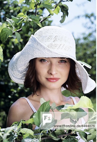1236869 outdoor summer day people woman young 20-25 girl brunette fringe blouse white portrait close up vertical smile smiling hat