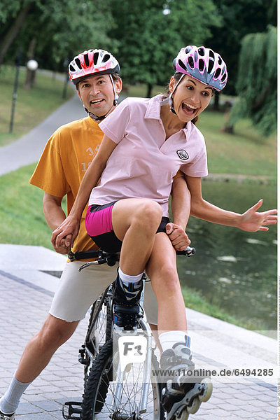 1239287 outdoor day summer vacation people woman young 20-25 girl smile smiling blouse pink shorts black park relax rest sport helmet vertical couple man dark haired helmets blouses orange ride bike mime emotions scream sit water lake 25-30