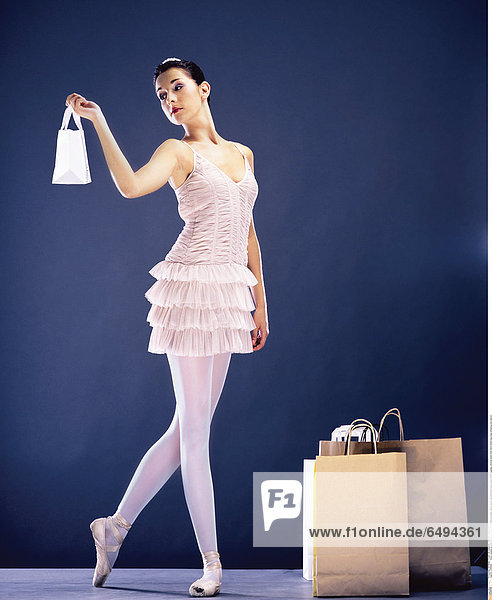 1236962 indoor people woman brunette young 25-30 ballerina ballet dance show representation play dress white leggings vertical stand hold hand hands bag bags shopping bun dancer