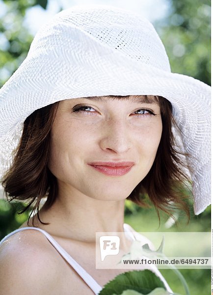1236880 outdoor summer day people woman young 20-25 girl brunette fringe blouse white portrait close up vertical smile smiling hat
