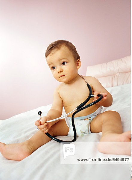 1239173 indoor flat room people boy child 0-5 baby fair haired stethoscope cold sick vertical foot feet barefoot nappy hand hands hold white sheet mime