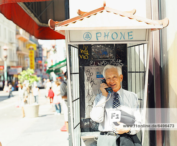 Senior man in phone booth