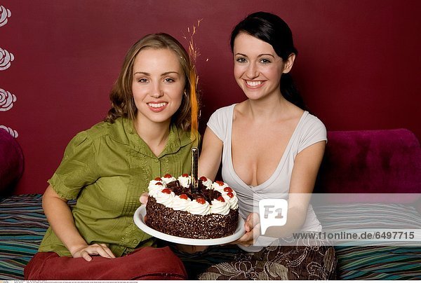1247330 indoor flat room people woman young girl 20-25 brunette sit dress red blouse green rest relax smile smiling horizontal women blonde blouses white sit bed bedroom plate hold hand hands cake sweets birthday