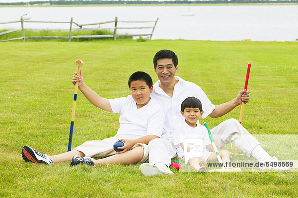 Father playing croquet with sons