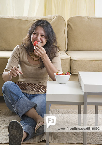 Frau  Boden  Fußboden  Fußböden  Zimmer  Erdbeere  jung  essen  essend  isst  Wohnzimmer