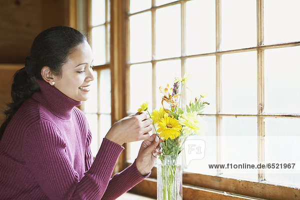 Junge Frau arrangiert einen Blumenstrauß