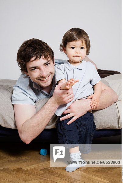Father playing with baby in the living room