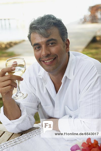 South American man holding glass of wine