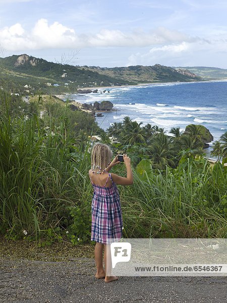 Girl taking picture of sea coast