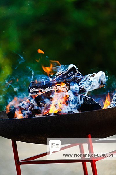 Burning wood in barbecue grill