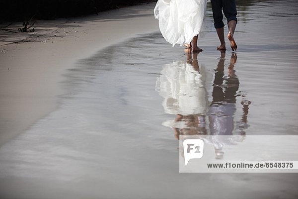 Newlywed couple walking on beach