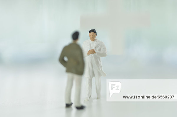Figurines doctor talking with patient