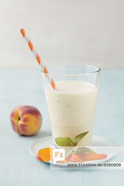 Vanilla and peach smoothie on table