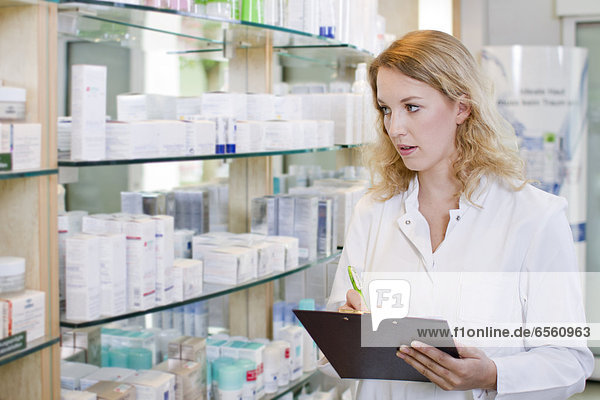Germany  Brandenburg  Pharmacist checking products in pharmacy