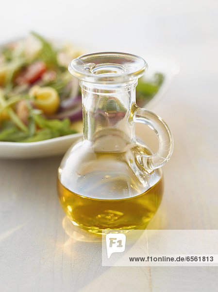 Ölflasche vor einem Salat