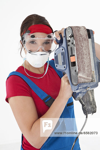 Young woman holding electric planer  portrait
