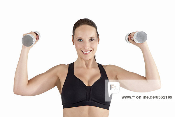 Young woman exercising with dumbbell  smiling  portrait