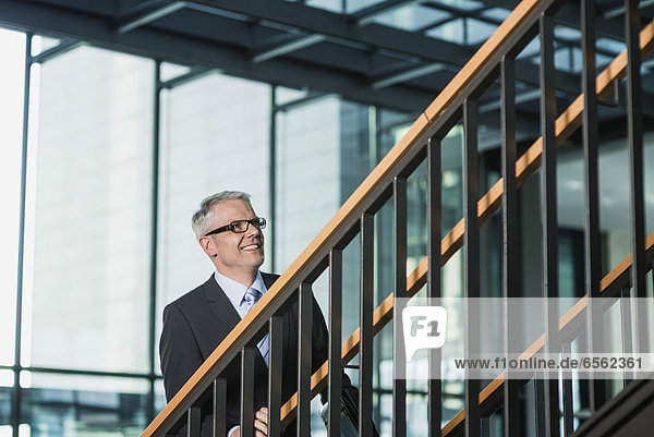 Deutschland  Stuttgart  Geschäftsmann beim Aufstieg auf die Bürotreppe