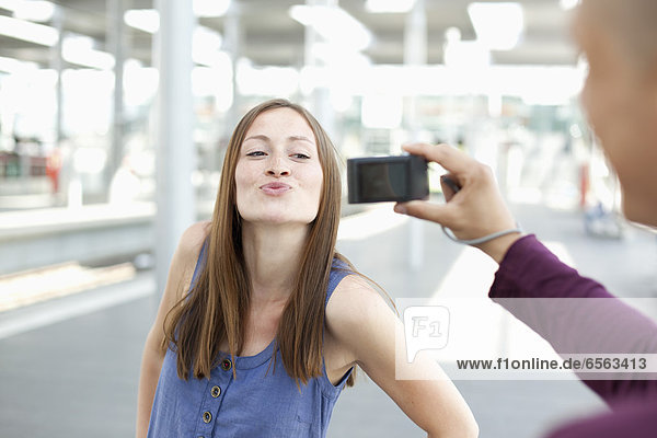 Young man taking photograph of woman