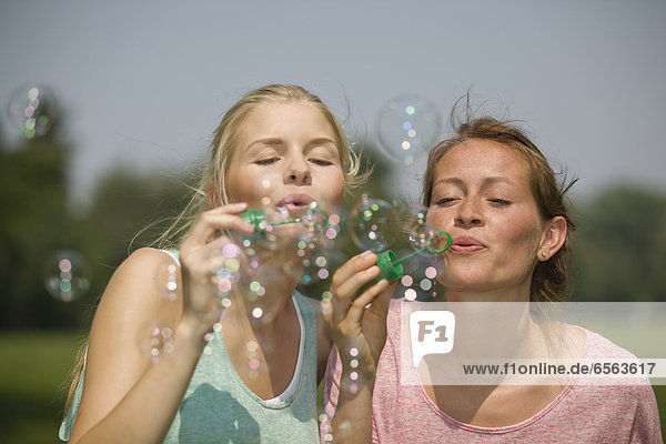 Deutschland  Nordrhein-Westfalen  Köln  Junge Frauen  die Seifenblasen blasen