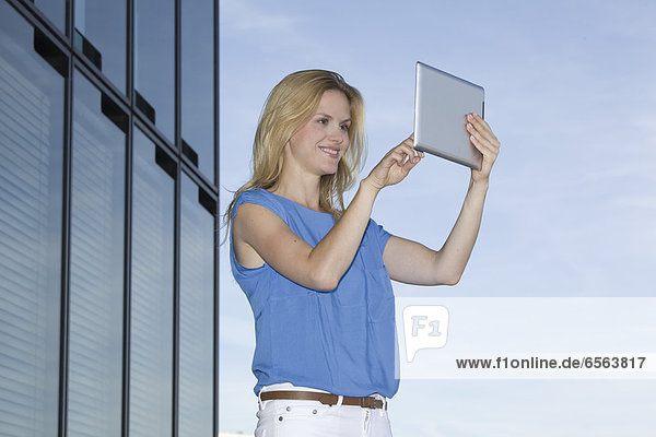 Europe  Germany  North Rhine Westphalia  Duesseldorf  Businesswoman using digital tablet  smiling