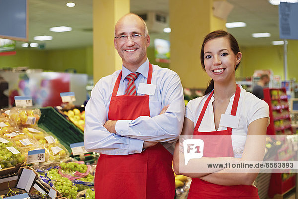 Mann und Frau im Supermarkt stehend  lächelnd  Portrait