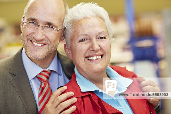 Germany  Cologne  Mature couple in supermarket  smiling  portrait