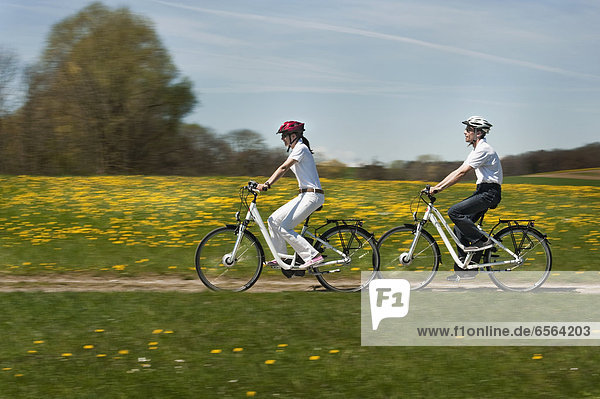 Man and woman riding electric bicycle
