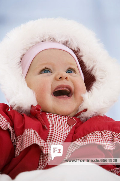 Kleines Mädchen im Schneeanzug  lächelnd