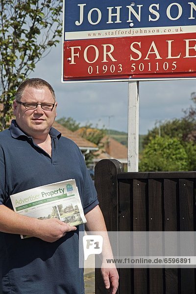 Mandatory Credit: Photo by E. M. Welch / Rex Features (1755188k) Model Released - Man looking at a for sale board property hunting Various - Jun 2012