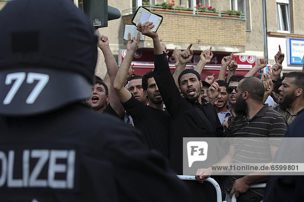 Protest gegen eine islamfeindliche Kundgebung von der Partei Pro Deutschland vor einer Moschee in Berlin-Neukölln  aufgebrachte Demonstranten strecken Ausgaben des Koran in die Luft  Berlin  Deutschland Europa
