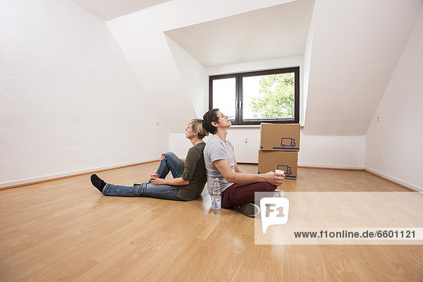 Young couple with moving boxes in the empty living room in a new apartment