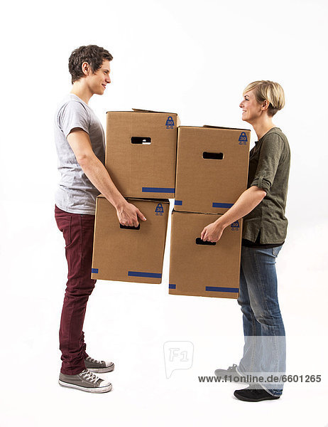 Young couple carrying moving boxes