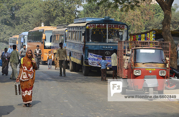 Street scene with Indian pilgrim buses  tuk tuk and pedestrians outside the ruins of the ancient University of Nalanda  Ragir  Bihar  India  Asia