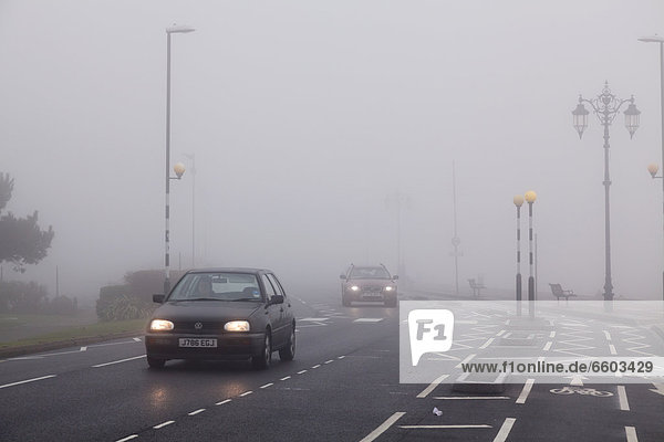 Cars travelling in urban environment with road markings on a foggy day with lights on  Portsmouth  Hampshire  England  United Kingdom  Europe