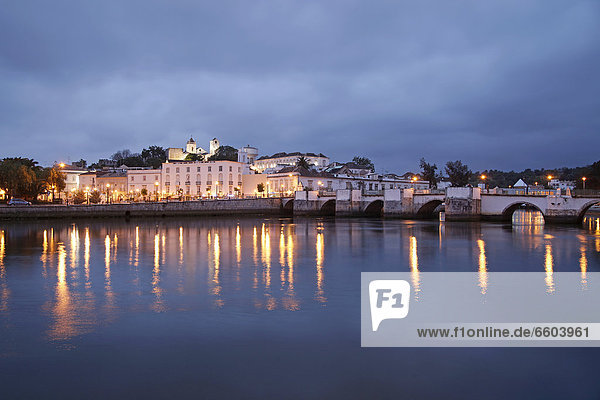 Die Lichter der Altstadt und die Römerbrücke spiegeln sich im Fluss Gilao  Tavira  Algarve  Portugal  Europa