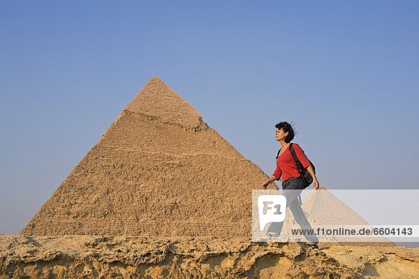 pyramidenförmig  Pyramide  Pyramiden  Rucksack  Frau  Wand  gehen  frontal  vorwärts  antik