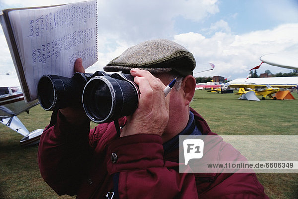 Plane Spotter Looking Through Binoculars
