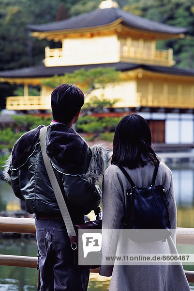 A Couple Looking At Kinkakuji Temple