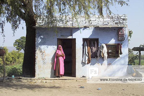 stehend Frau Wohnhaus Eingang Dorf pink Sari