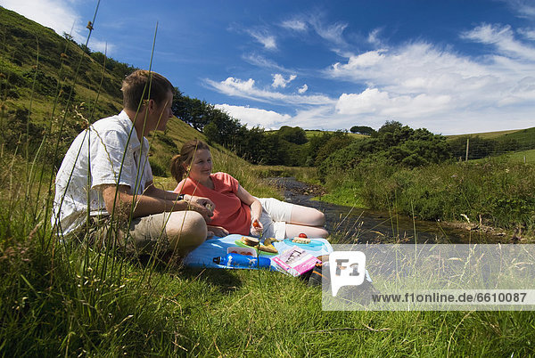 Couple Having Picnic Beside The River Exe
