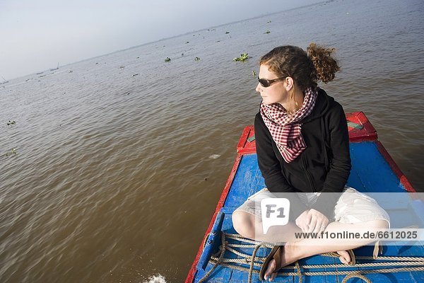 Young woman sitting on boat in Mekong Delta