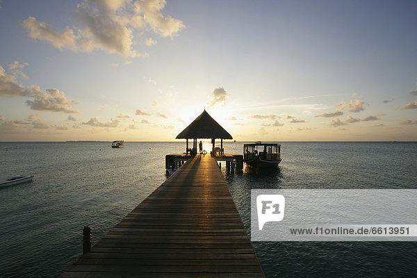 Wooden pier in ocean at sunset  Dhuni Kolhu Island Maldives