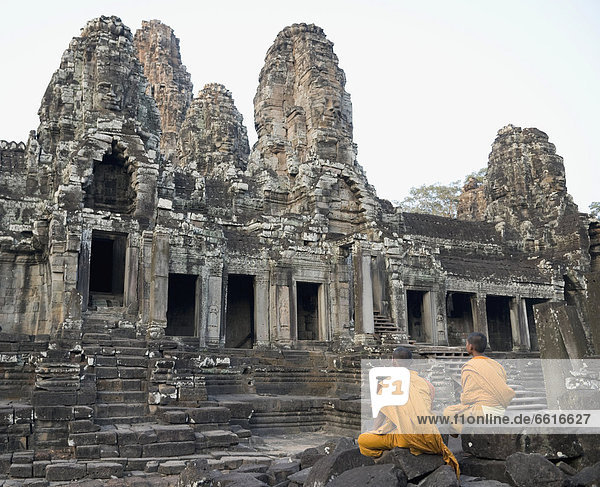 Buddhist Monks Sitting In Front Of Bayon Temple  Angkor Wat © Elena Roman Durante / Axiom