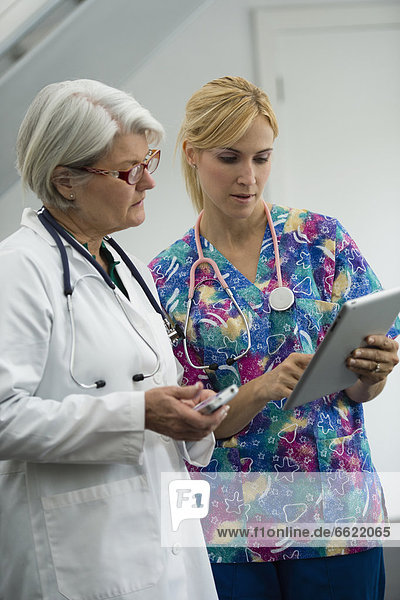 Caucasian nurse and doctor using digital tablet