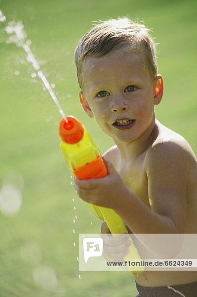 Little Boy Playing With A Watergun