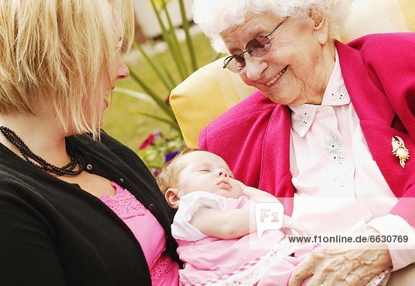 nebeneinander  neben  Seite an Seite  Senior  Senioren  Frau  halten  jung  Baby