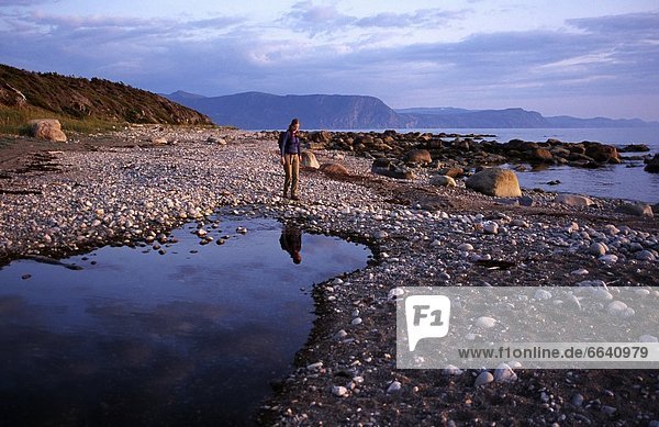 Person Walking On Beach With Tide Pools