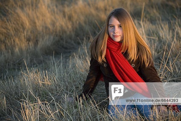 sitzend  Jugendlicher  Schal  Feld  rot  Kleidung  Gras  Mädchen