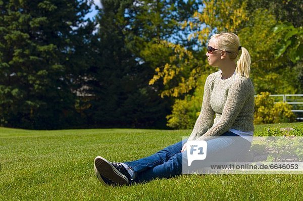 Young Woman Sitting In The Grass